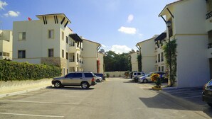 A parking lot with multiple cars parked in front of a row of apartment buildings. - In Playa del Carmen, Mexico (Playa del Carmen)