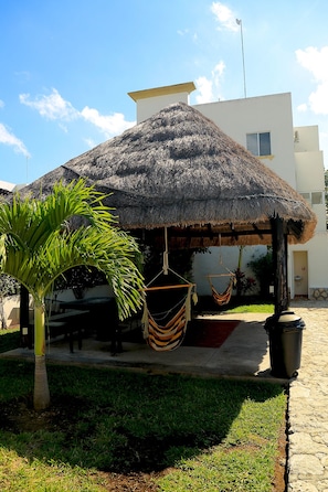 Relax in a serene outdoor space with a hammock and lush greenery.