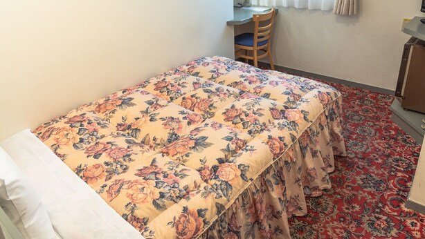 A room with a bed, a desk, and a chair. - Asaka Daily Hotel (Asaka)