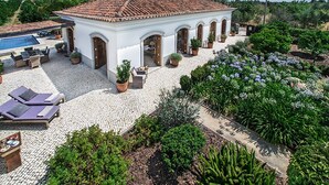 A villa with a tiled roof, a swimming pool, outdoor seating, and a garden. - Beautiful Charming villa with pool, near Fabrica Beach in Cacela Velha. (Vila Nova de Cacela)