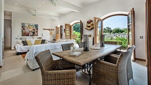 A spacious room with a large dining table, wicker chairs, and a ceiling fan. - Beautiful Charming villa with pool, near Fabrica Beach in Cacela Velha. (Vila Nova de Cacela)