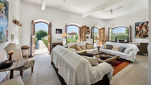 A spacious living room with a high ceiling, large windows, and a view of the outdoors. There are multiple seating areas and a dining table. - Beautiful Charming villa with pool, near Fabrica Beach in Cacela Velha. (Vila Nova de Cacela)