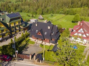 A large, multi-story building with a prominent central structure featuring a steeply pitched roof and multiple windows. - Pod Jesionem by Interhome (Zakopane)