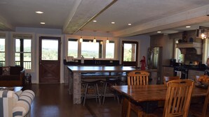 A spacious kitchen with a large island, wooden chairs, and a dining table.