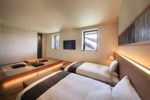Habitación de hotel con dos camas, un televisor de pantalla plana y un gran ventanal.