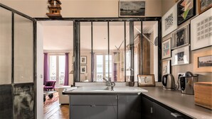 A modern kitchen with a large island, stainless steel appliances, and a view of the living area.