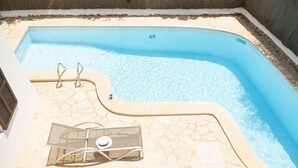 A swimming pool with a stone deck and a lounge chair. - Villa with 3 bedrooms, private pool, walking distance to the beach. (Cala D' Or)