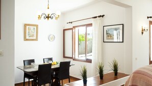 A dining area with a table, chairs, and potted plants. - Villa with 3 bedrooms, private pool, walking distance to the beach. (Cala D' Or)