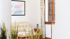 A cozy living room with a sofa, a coffee table, and a painting on the wall. - Villa with 3 bedrooms, private pool, walking distance to the beach. (Cala D' Or)