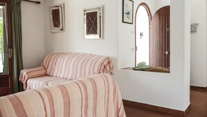 A bedroom with two beds, a wooden door, and a window with curtains. - Villa with 3 bedrooms, private pool, walking distance to the beach. (Cala D' Or)