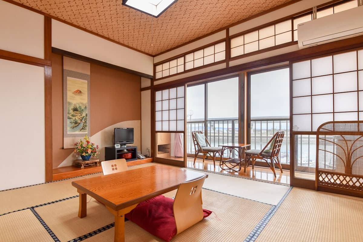 A traditional Japanese room with tatami flooring, a low table, and sliding doors.