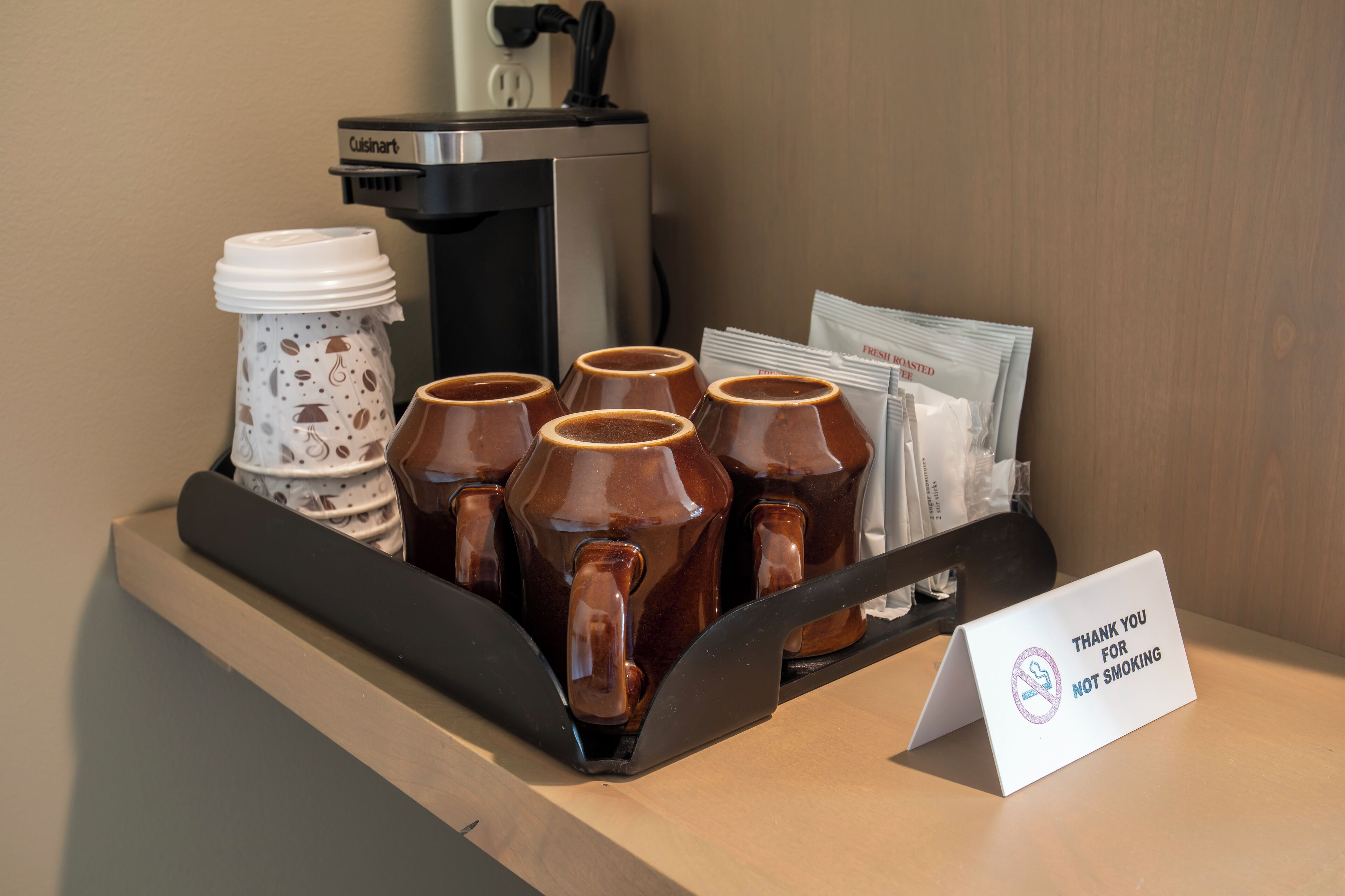 Una estación de café con un letrero que dice 'Gracias por no fumar'.