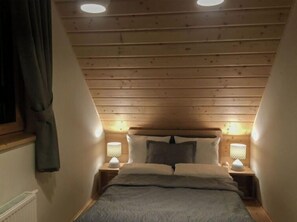 Cozy single-room accommodation with a bed, bedside tables, and lamps.