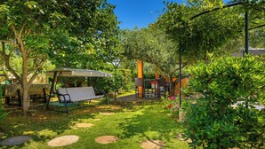 A garden with a bench, a pergola, and a pathway. - Authentic Istrian House - Apartment with saltwater pool- 15 min from Kamenjak (Pula)