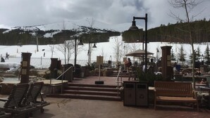 An outdoor seating area with benches and a covered seating area, a small pool, and a ski lift in the background. - Upscale slope side resort in Breckenridge, CO (Breckenridge)
