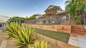 Relax in a spacious outdoor area surrounded by tropical plants and a patio with comfortable seating.