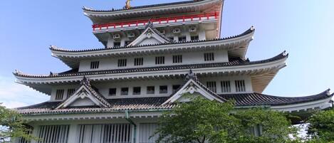 Un edificio japonés tradicional de varios niveles con barandilla roja en el nivel superior.