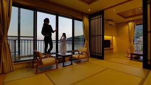 A room with tatami flooring, a balcony with a view, and traditional Japanese sliding doors. - Atami Onsen Hiratsuru (Atami)