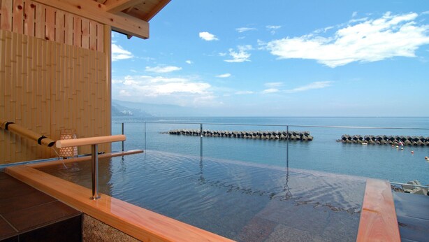 An infinity pool with a wooden deck and a view of the sea. - Atami Onsen Hiratsuru (Atami)
