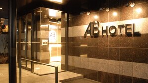 A hotel entrance with a glass door, a metal staircase, and the hotel's name 'ABHOTEL' on the wall. - Ab Hotel Isesaki (Isesaki)