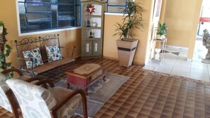 A cozy living area with a sofa set, a wooden coffee table, a bookshelf, and a potted plant.