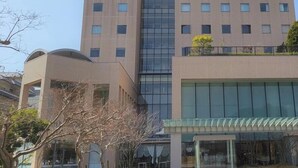 A multi-story building with a modern architectural design, featuring a mix of glass and brick facades, and a flat roof. - Yuda Onsen Centcore Yamaguchi (Yamaguchi)