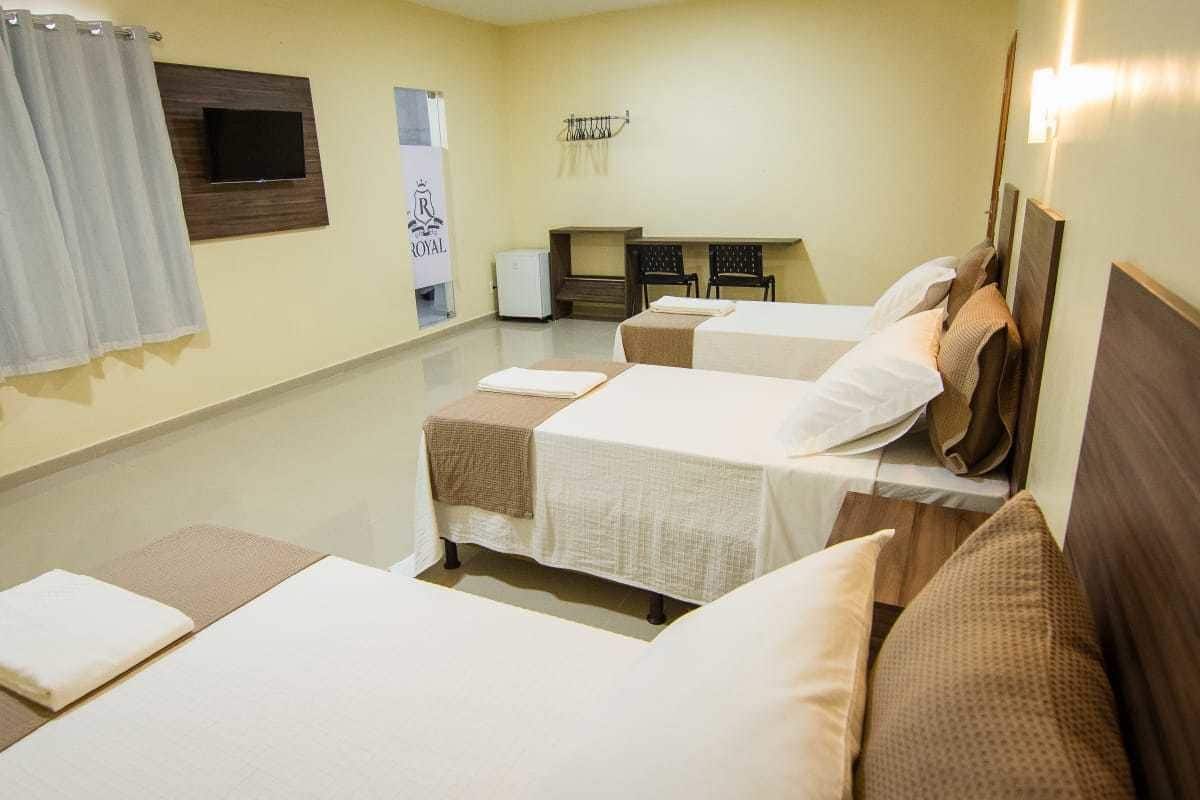 Une chambre d’hôtel avec deux lits, un petit bureau, une télévision et un espace douche.