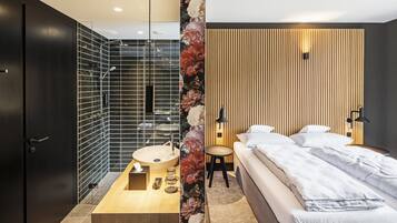 Un baño moderno con cabina de ducha de vidrio, tocador de madera y lavabo.