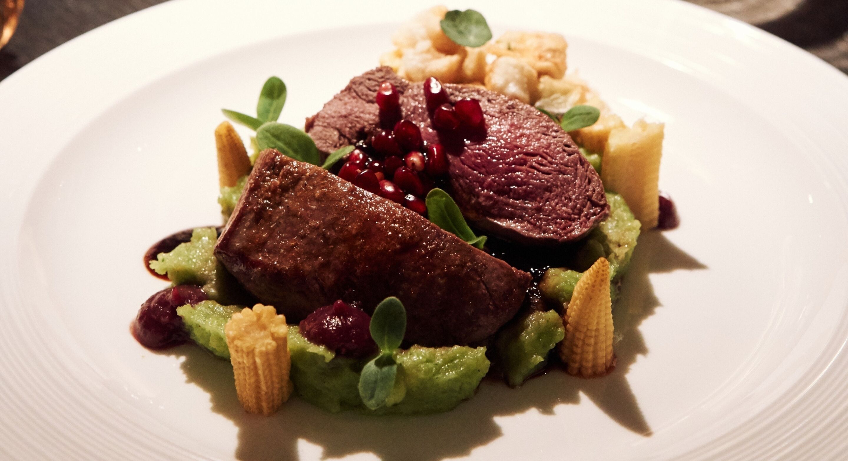 Ein Teller mit Fleisch, Gemüse und einer kleinen Soße.