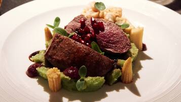 Ein Teller mit Fleisch, Gemüse und einer kleinen Soße.