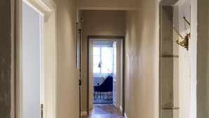 A hallway with wooden flooring, white walls, and a door on the left. - Santa Croce Terrace - Luxury nest (Firenze)