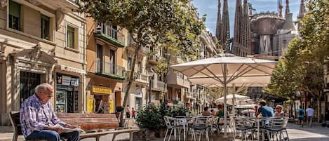 A plaza with outdoor seating, benches, and umbrellas.