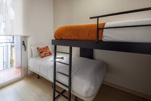 A bunk bed with a ladder, a white mattress, and an orange blanket.