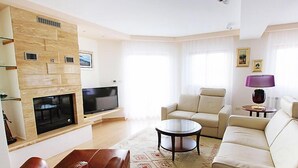 A modern living room with a flat-screen TV, leather sofas, a coffee table, and a patterned rug. - Villa Mustra by Interhome (Trogir/Okrug Donji)