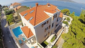 A multi-story building with a swimming pool, terracotta roof tiles, and a view of the sea. - Villa Mustra by Interhome (Trogir/Okrug Donji)
