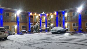 Et hotel med et overdækket udendørsområde, flere balkoner og en central trappe.