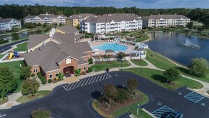 Un complejo residencial con piscina, área de juegos para niños y una gran extensión de agua.