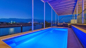 Ein Swimmingpool mit Bergblick und einer überdachten Terrasse.