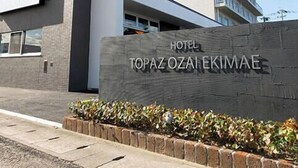 A hotel entrance with a sign reading "HOTEL TOPAZOZAI EKIMAe".