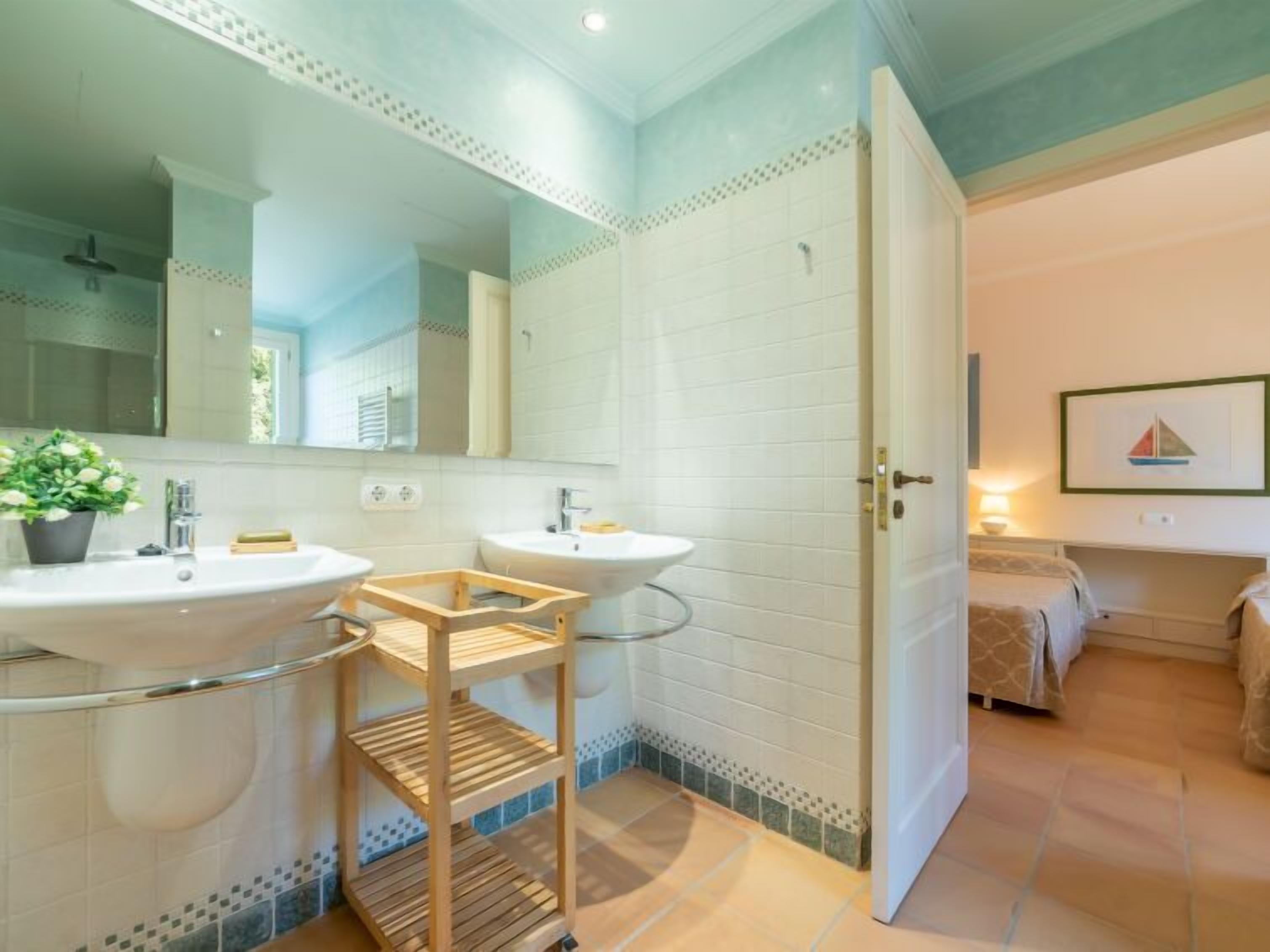 Un bagno con due lavabi, uno specchio e una mensola in legno.