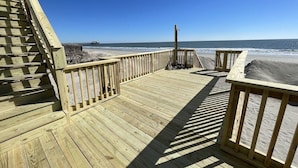 A wooden deck with a view of the ocean and a pier in the background. - Family Seaclusion - Oceanfront in Garden City Beach (Garden City Beach)