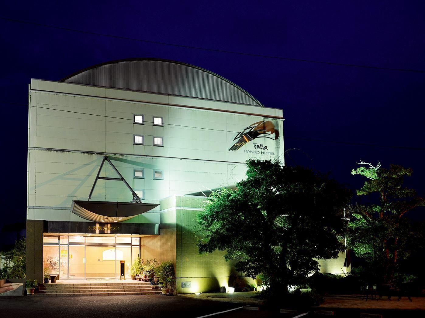 A hotel with a large satellite dish, a dome-shaped roof, and a sign for 'Kanoko Hotel'.