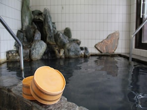 A hot spring area with stone steps leading into the water, metal railings, and a tiled wall in the background. - Tara Kanko Hotel (Tara)