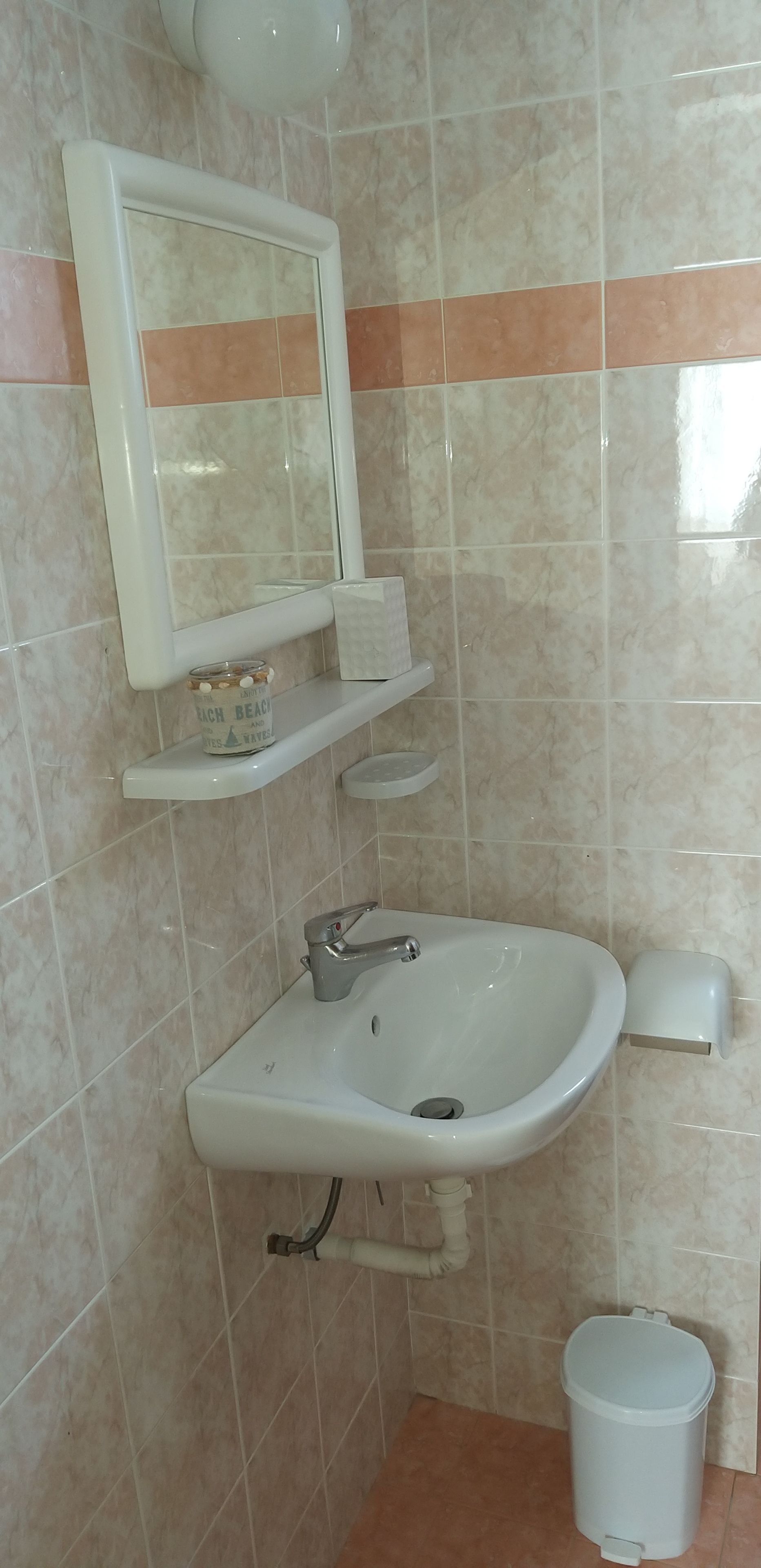 A bathroom with a sink, mirror, and toilet.