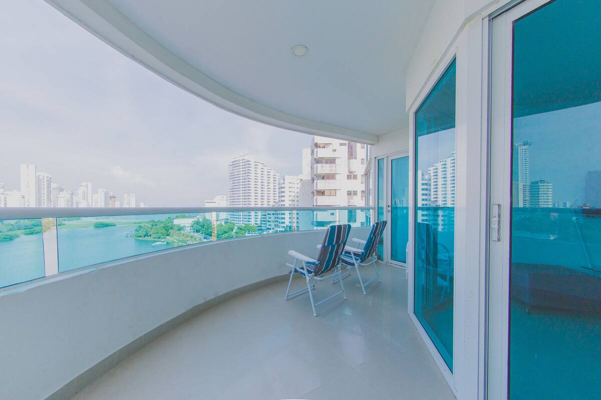 A balcony with a view of a city skyline and a river.