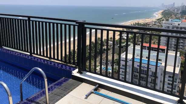 Un balcon avec vue sur une plage et l’océan.