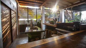 Una cocina rústica con vigas de madera, una barra y vistas a una escalera.