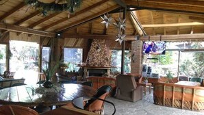Un comedor rústico de madera con una mesa grande, sillas y una estrella decorativa colgante.