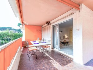 A balcony with a table set for two, a chair, and a potted plant. - Les Patios by Interhome (Saint-Tropez)