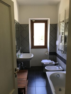 Kombination af bruser/badekar, hårtørrer, bidet, håndklæder
